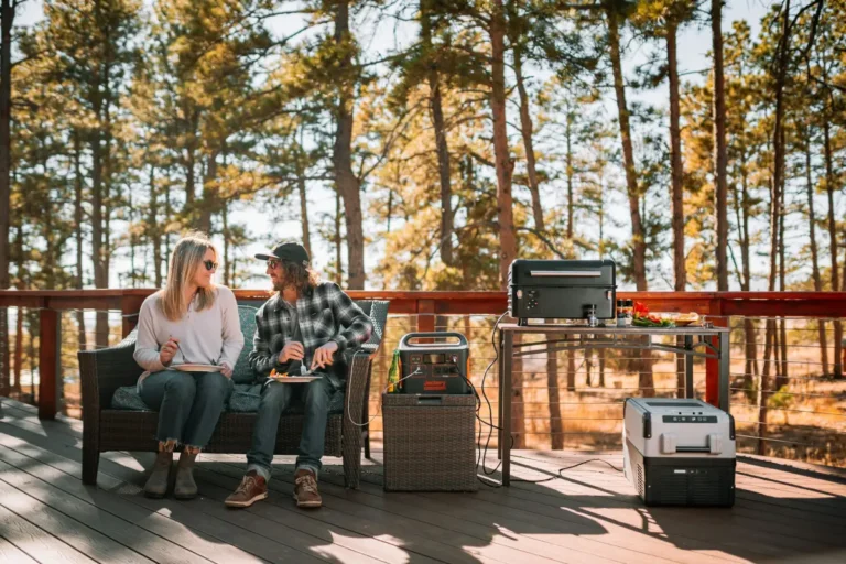 A man and woman working on a laptop outdoors using a portable power station, illustrating reliable off-grid energy for home office and remote work.