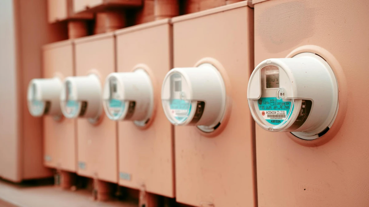 Row of electric meters measuring household energy consumption.