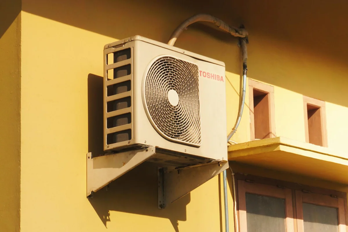 An outdoor air conditioning condenser unit illustrating what uses the most electricity in a home during peak summer months and high-heat periods.
