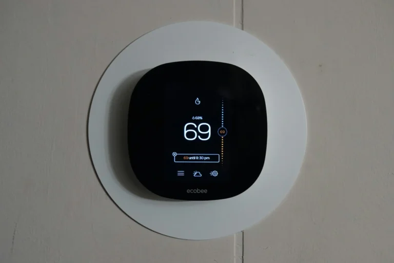 A close-up of a Nest 4th Gen display showing how much a smart thermostat saves on electric bills through real-time energy usage data and AI optimization.