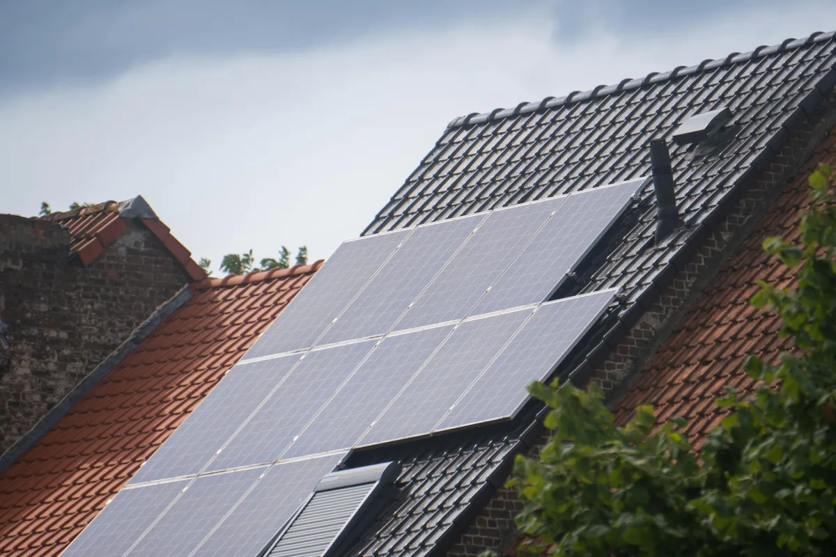 An aerial view of sleek black monocrystalline solar panels installed on a residential rooftop, highlighting the uniform crystal structure used for maximum home energy efficiency.