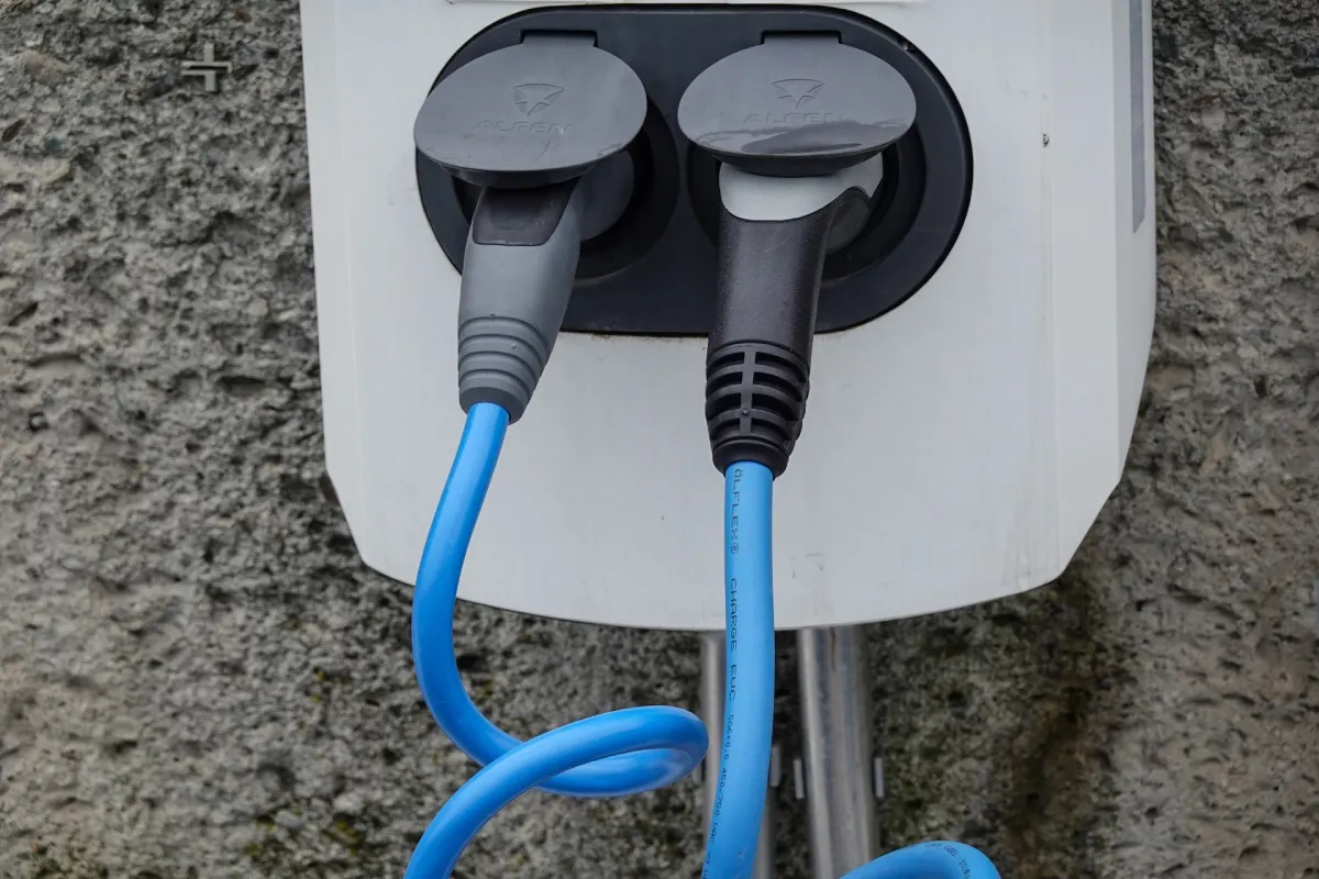 A clean white charging handle resting in its wall dock socket from a fresh residential EV charger installation.